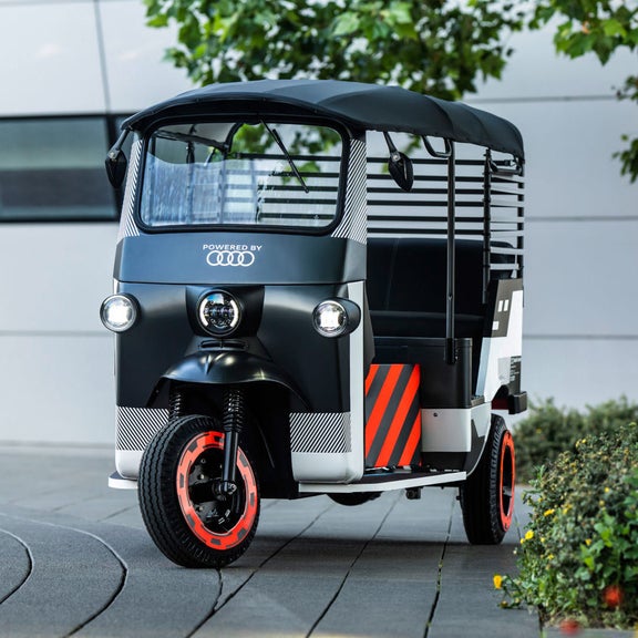 Front view of an e-rickshaw on a forecourt.