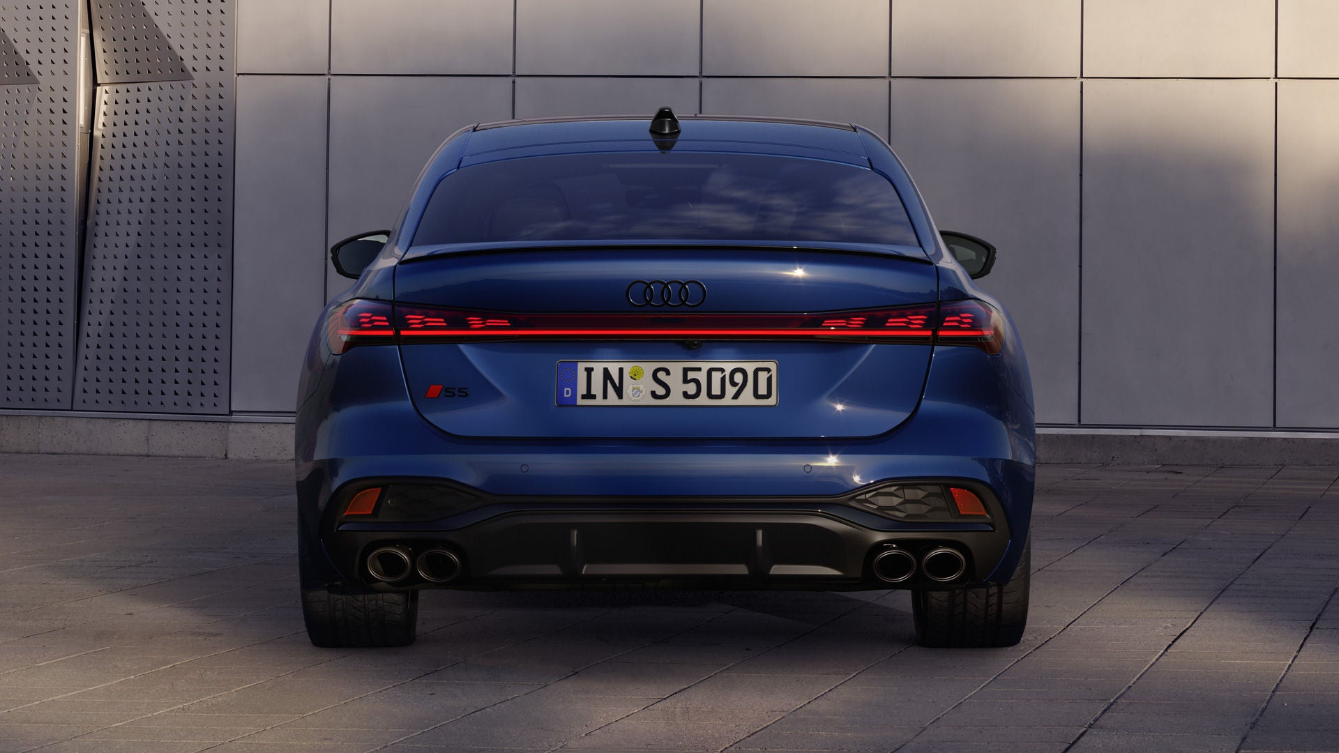 Heckansicht der S5 Limousine, welche vor einer Gebäudefassade steht.