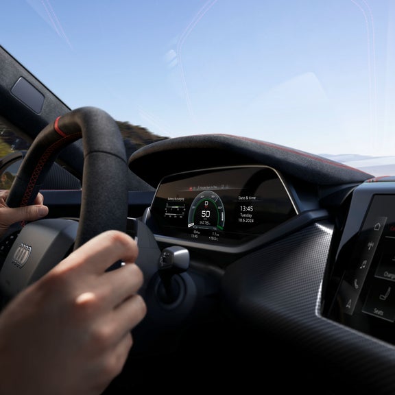 Primo piano del cockpit digitale dell’Audi RS e-tron GT che mostra velocità, stato della batteria e data su display ad alta definizione.