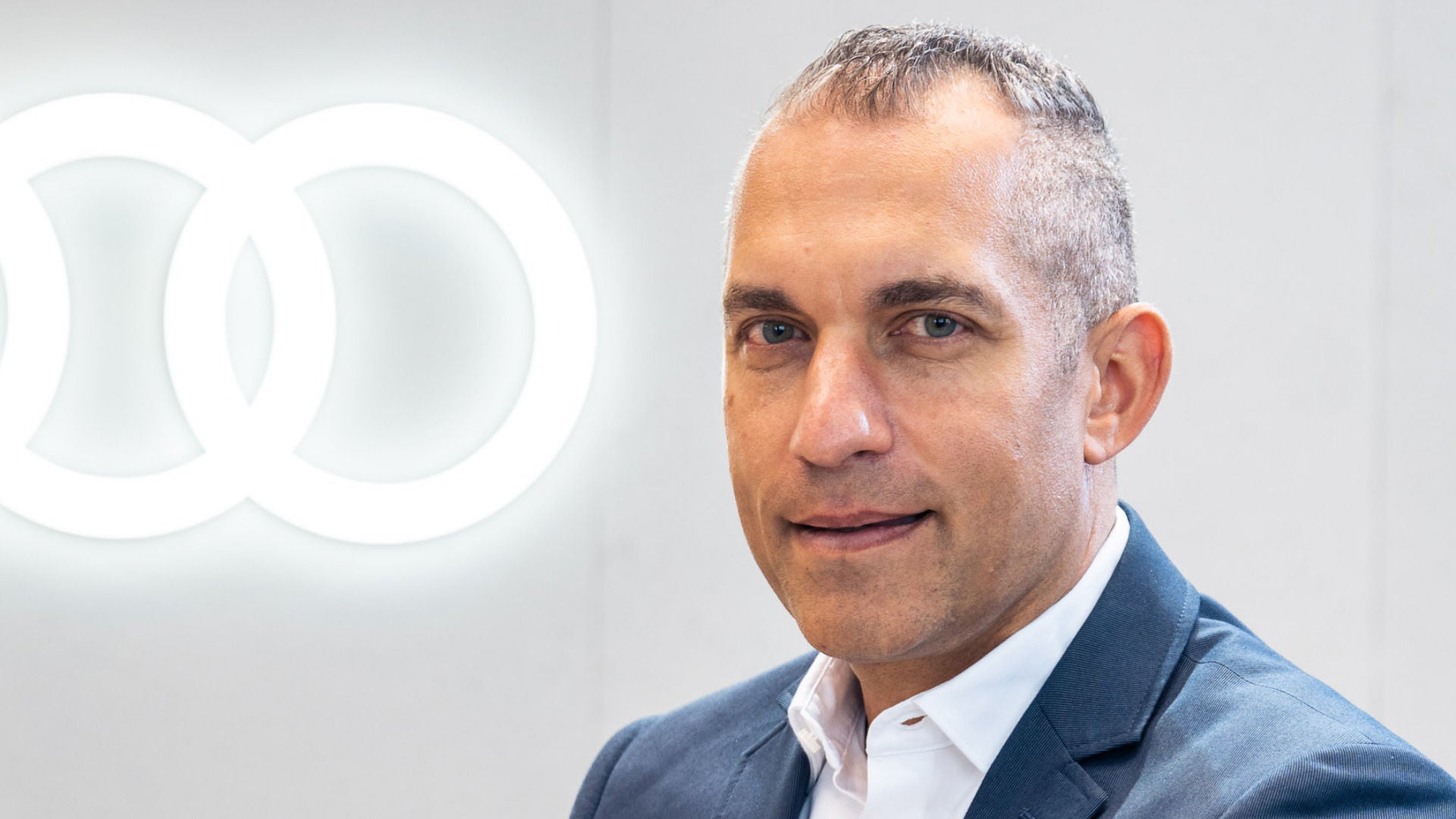 Portrait of Daniel Patnaik next to the Audi logo