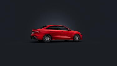 De Audi RS 3 Berline, van opzij gezien tegen een donkere achtergrond.