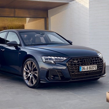 A blue Audi sedan parked on a modern driveway.
