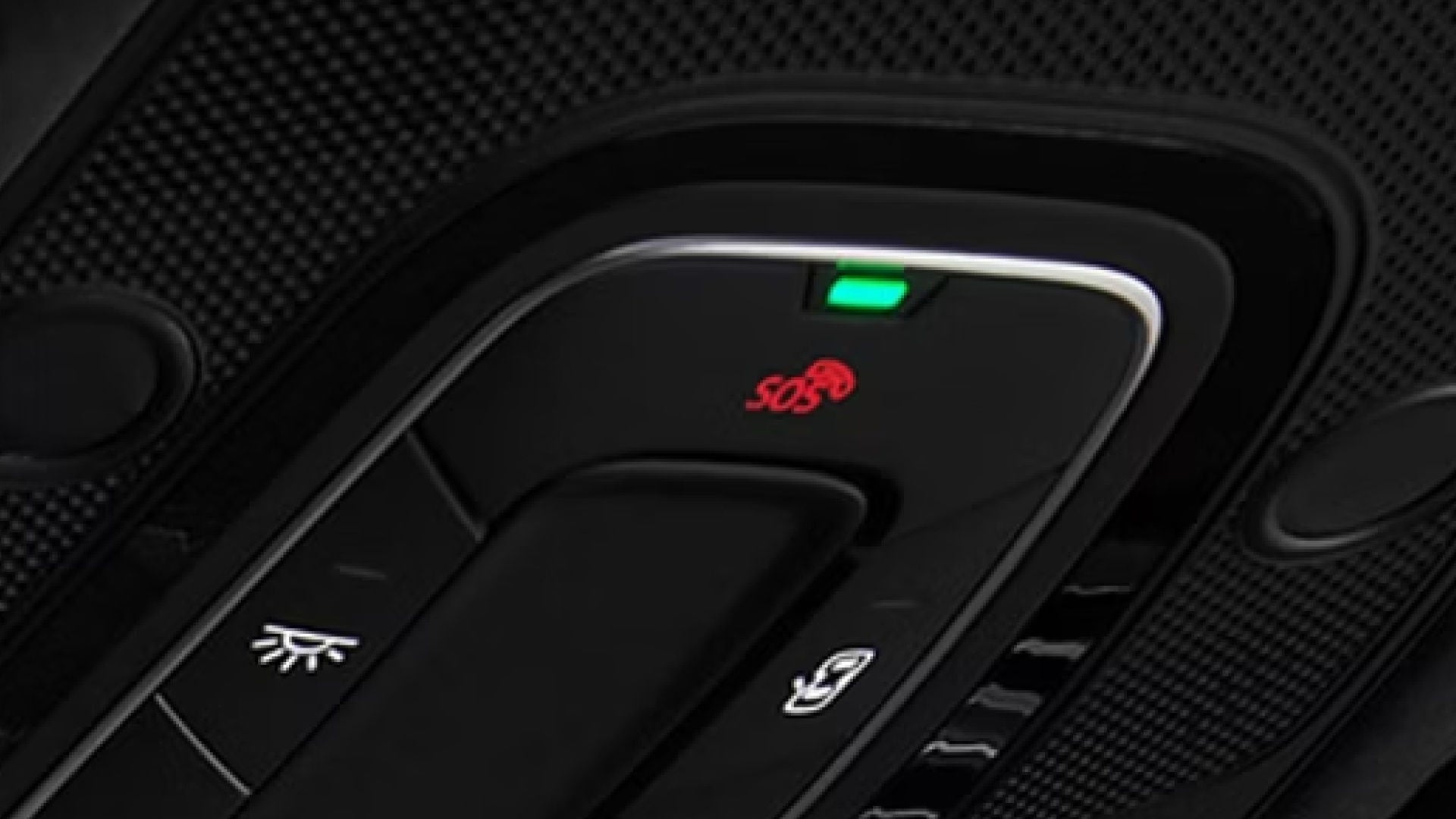 Close-up of a car control panel showing an illuminated SOS button with a red icon, and a green indicator light above it.
