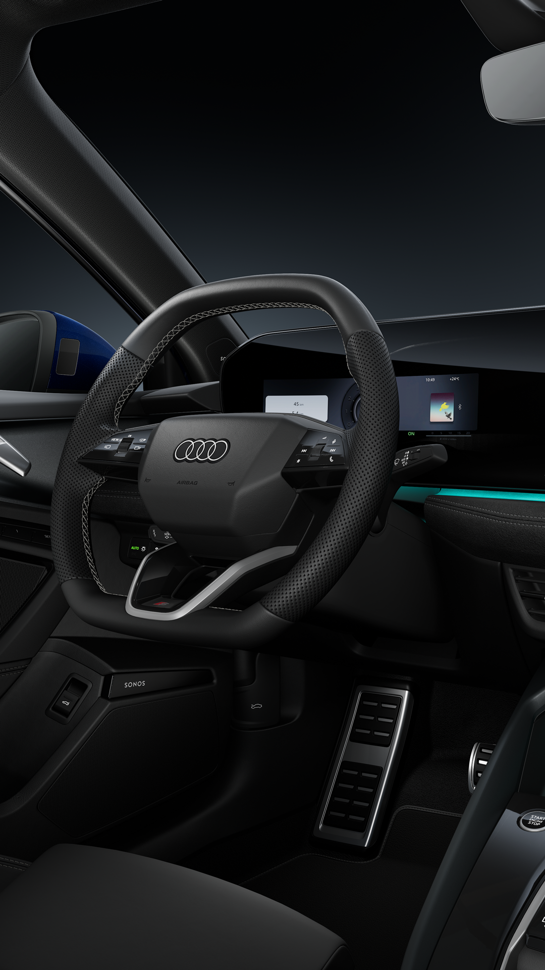 Seitlicher Blick auf das Cockpit mit Sportlenkrad, das geschwungene Panoramadisplay und das Ambiente-Licht.