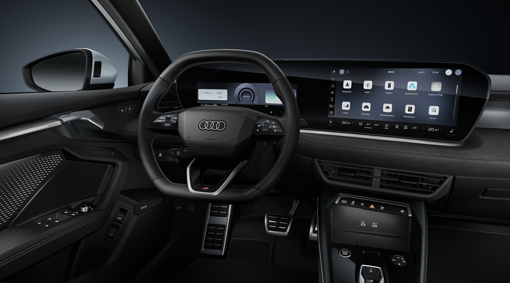 Blick auf das Cockpit mit Fokus auf das Sportlederlenkrad und das geschwungene Panoramadisplay.