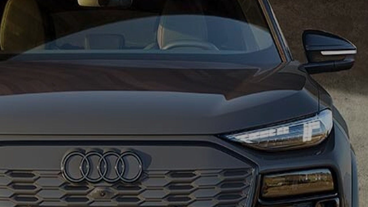 Close up of the front of an Audi car, with Audi logo visible and driver side