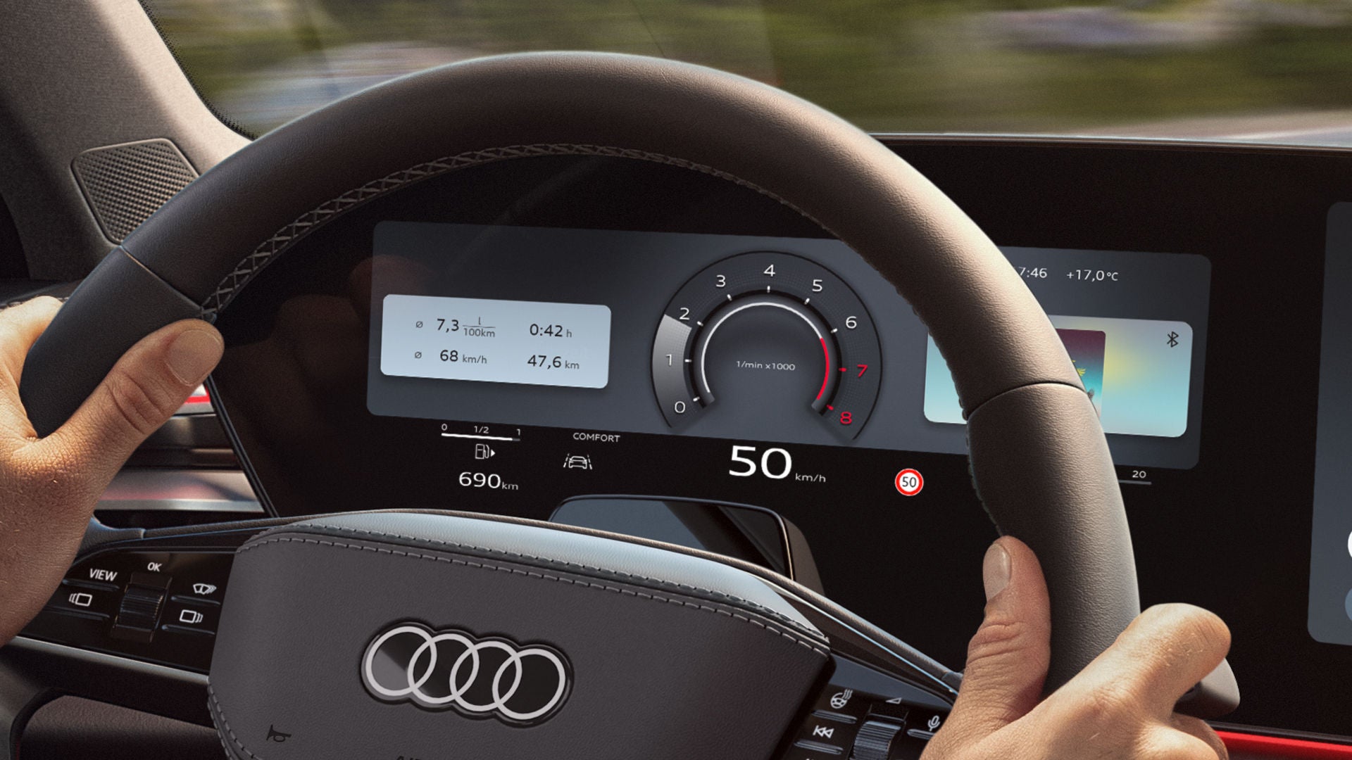 View from the back seat of a young man sitting behind the wheel of an A6 Saloon driving along a coastal road.