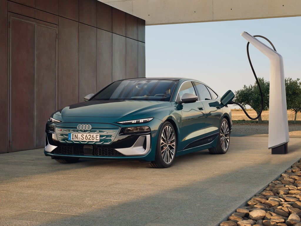 De S6 Sportback e-tron in een schuin frontprofiel, aangesloten op een laadstation.