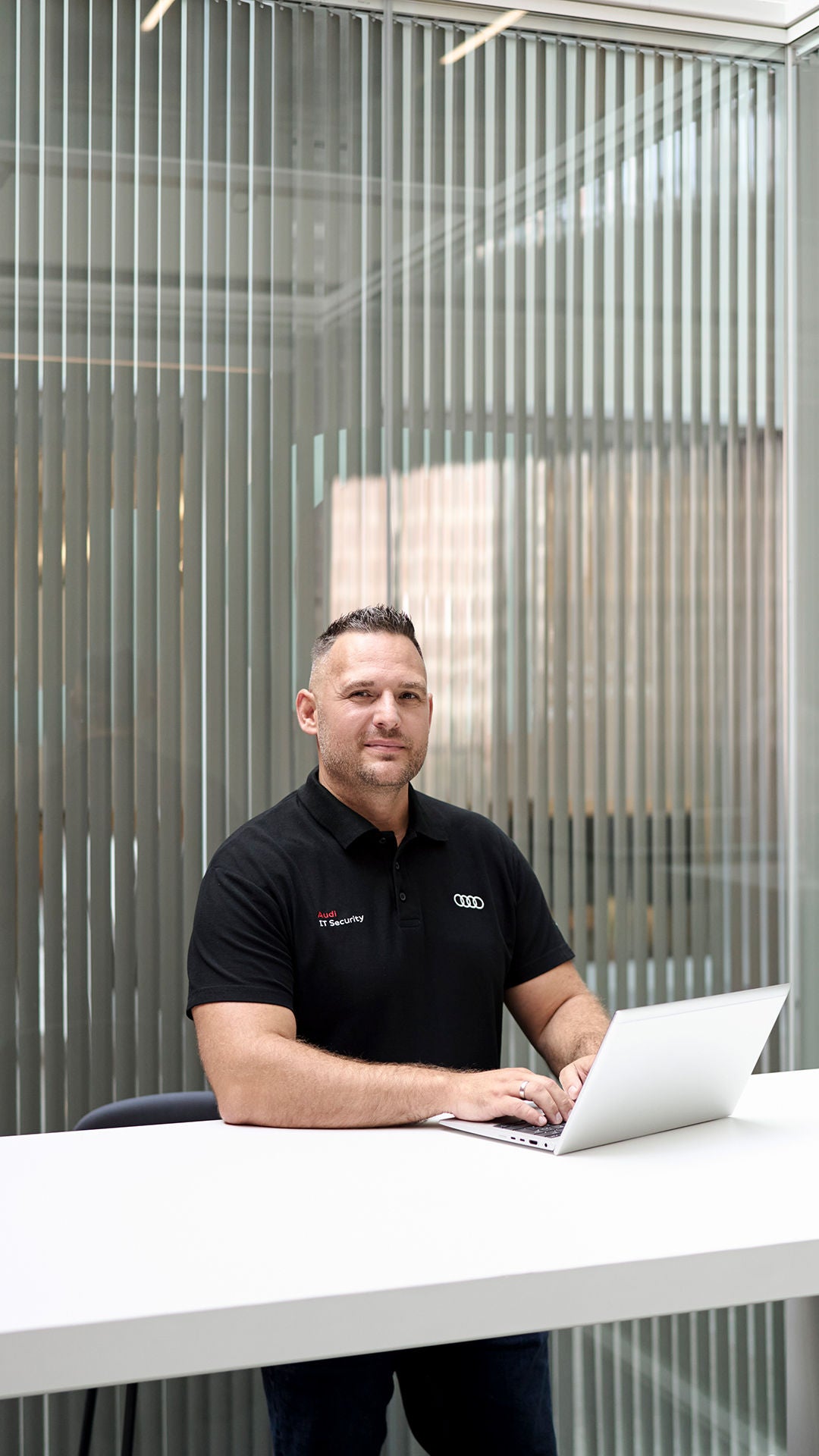 Andreas Walter schaut in die Kamera und hat einen Laptop vor sich