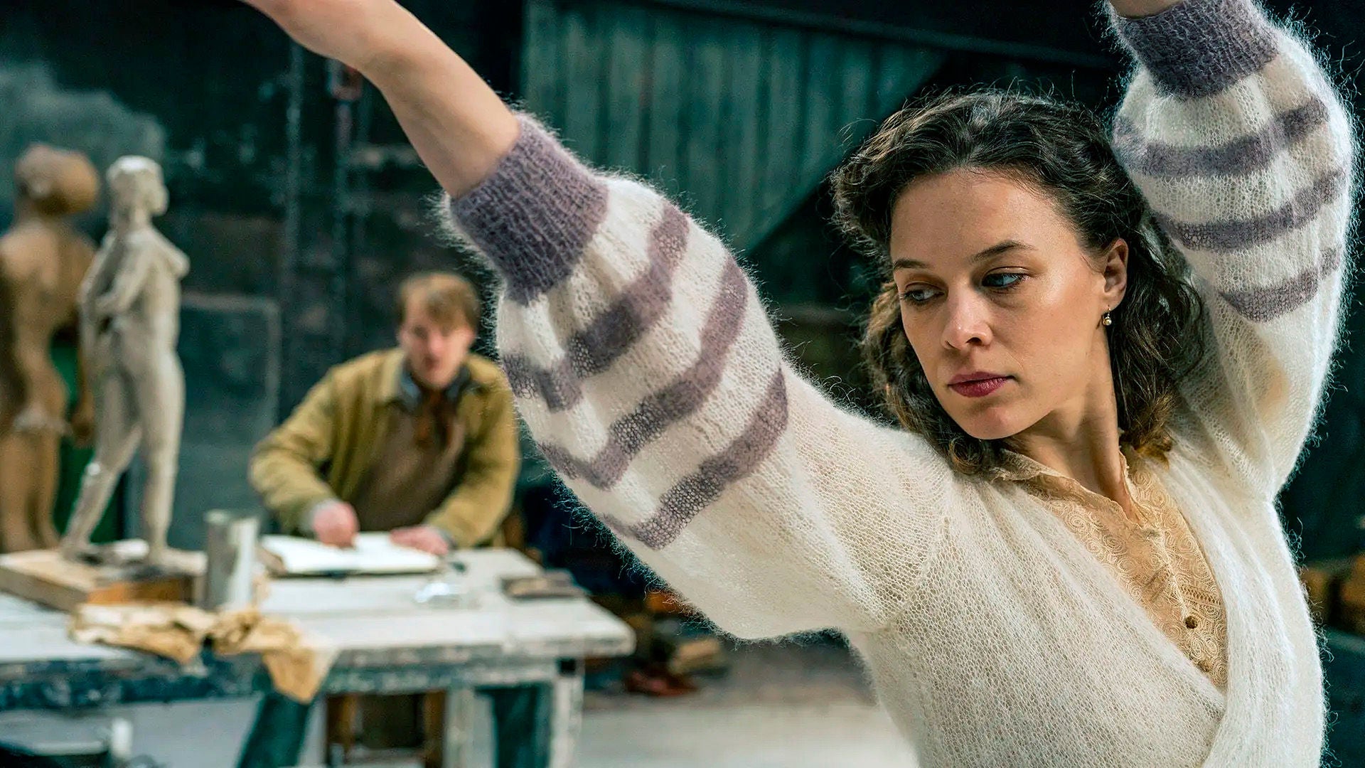 Eine Frau posiert für Studien in einem Atelier.