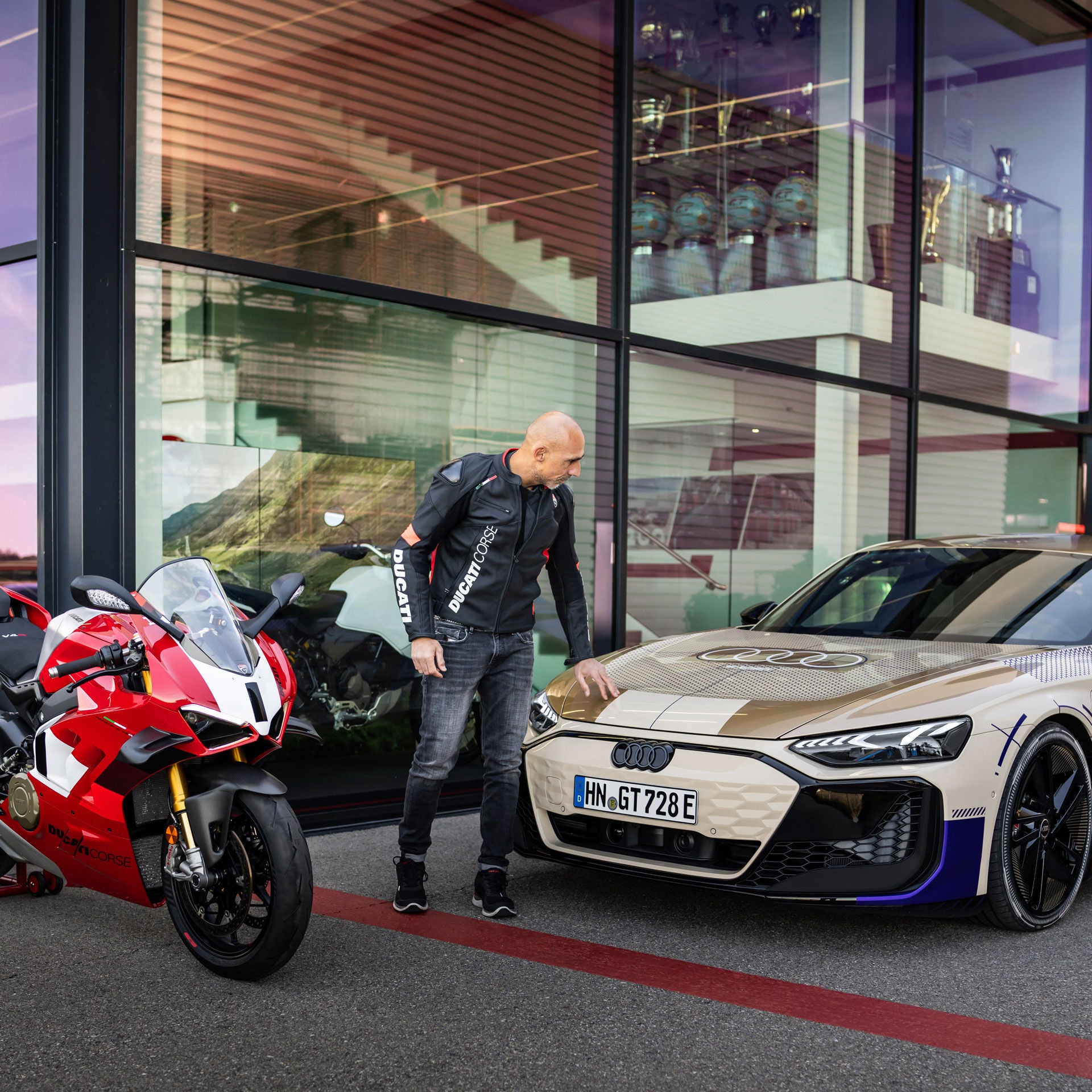 Ducati test boss Alessandro Valia strokes the bonnet of the Audi e-tron GT