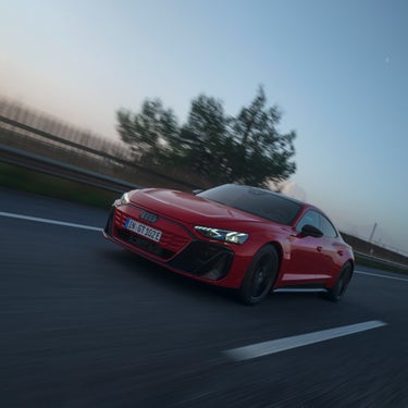 Ein Audi e-tron GT quattro fährt schnell auf einer Straße.