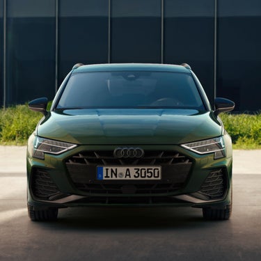 Front view of a green Audi car with a license plate.