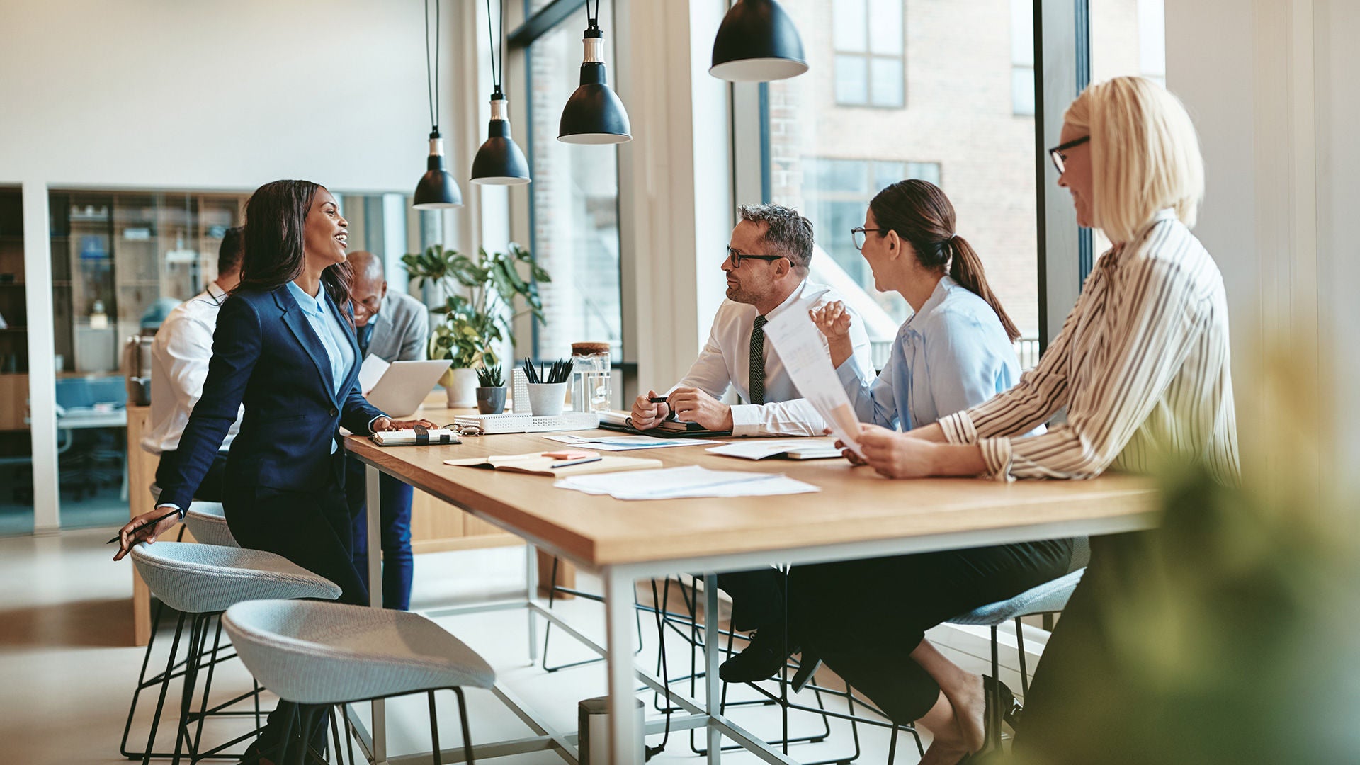 Mehre Mitarbeiter_innen sitzen gemeinsam an einem Tisch und haben ein Meeting