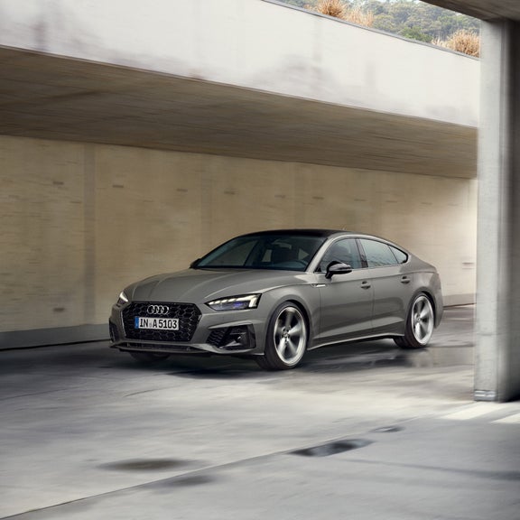 A grey Audi car driving through an underpass.