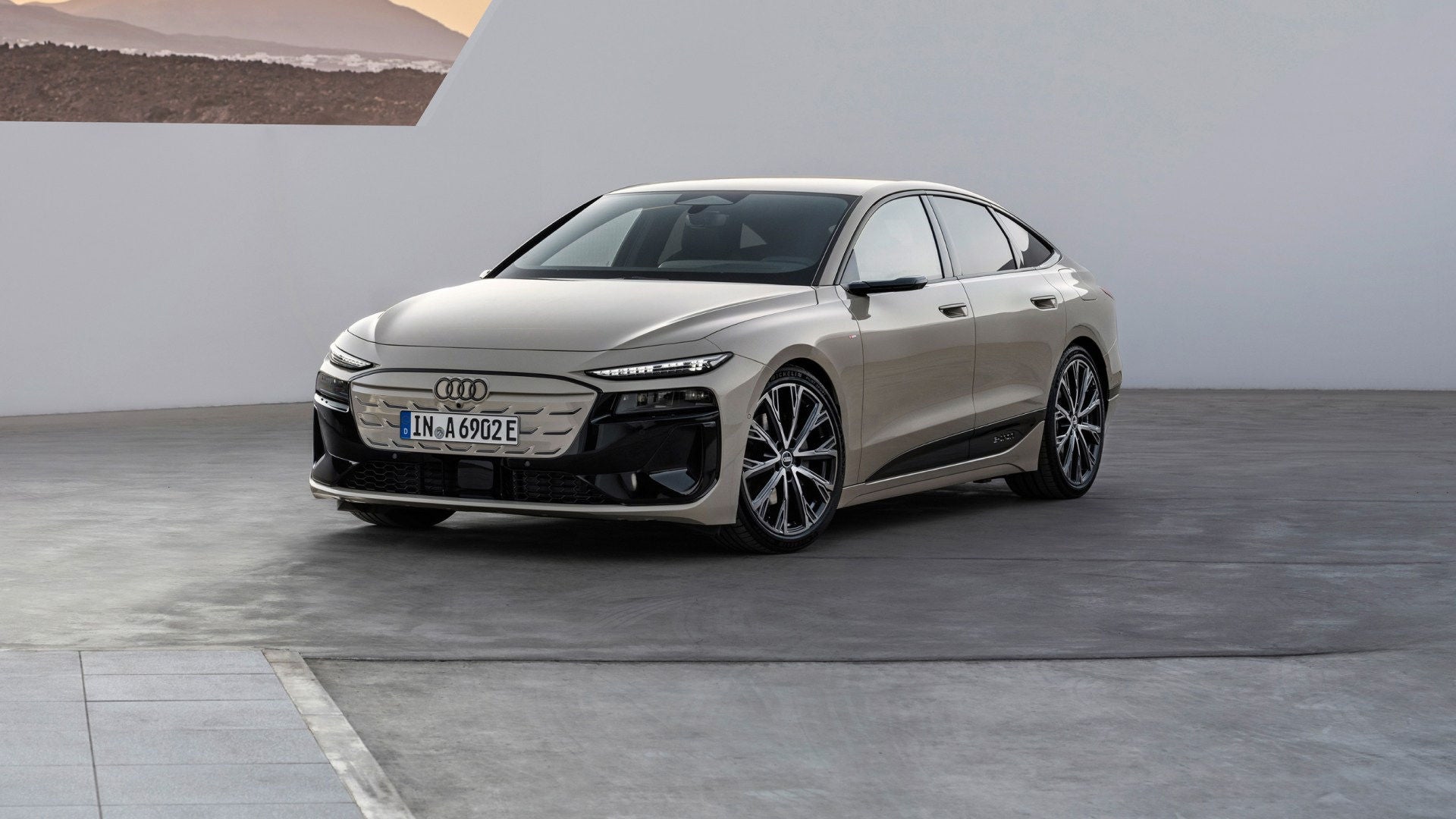 Een Audi A6 Sportback e-tron schuin van voren op een moderne plavuizenvloer.