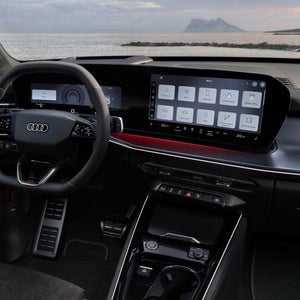 Cockpit view of steering wheel and panoramic display with touchscreen and included functions.