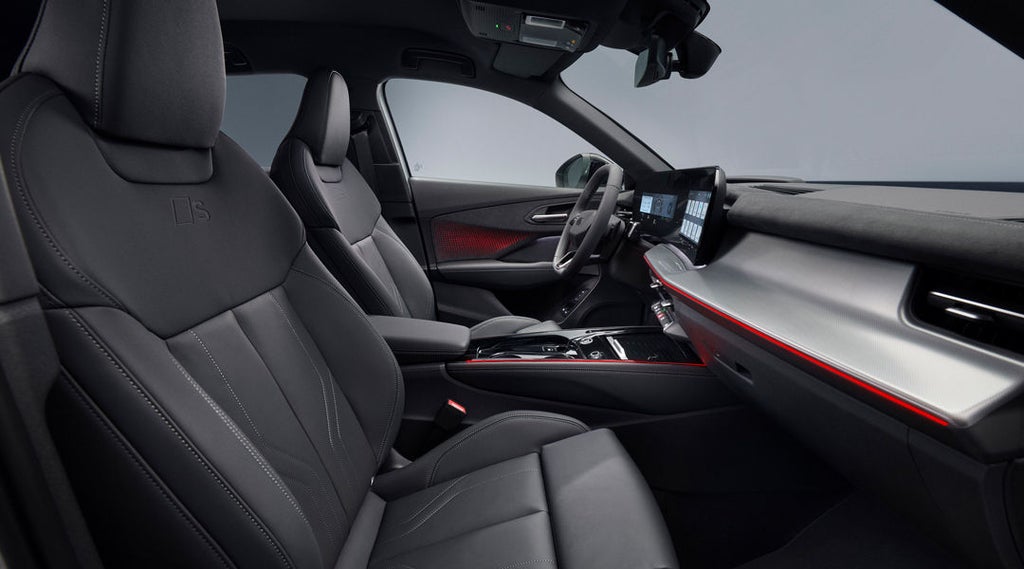 Front interior of the Q3 SUV in red ambient lighting with raised seats and panoramic display.