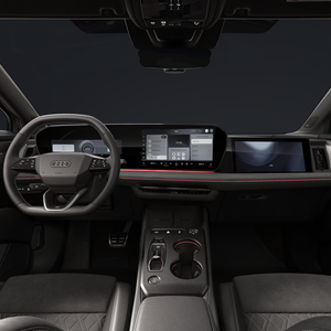 Een blik op de cockpit met het stuurwiel met platte onderkant, het gebogen panoramische display en het passagiersdisplay.