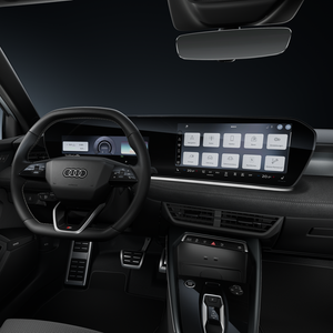 Blick auf das Cockpit mit Fokus auf das Sportlederlenkrad und das geschwungene Panoramadisplay.