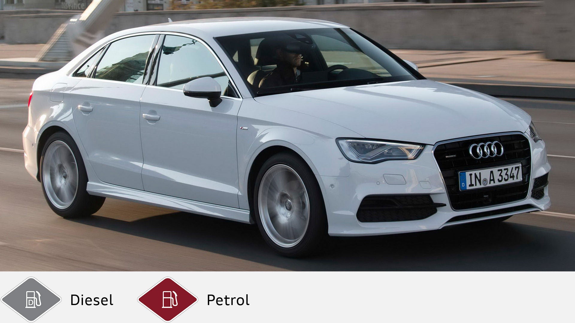 White Audi A3 sedan driving in a built-up area, photographed from the side. Gray diesel symbol and red petrol symbol at the bottom.