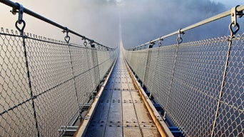 A suspension bridge that leads into the fog