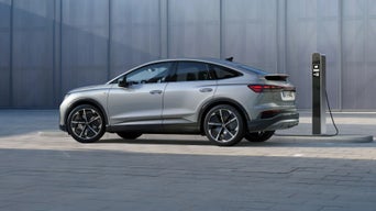 A silver Audi electric vehicle charging at a public station