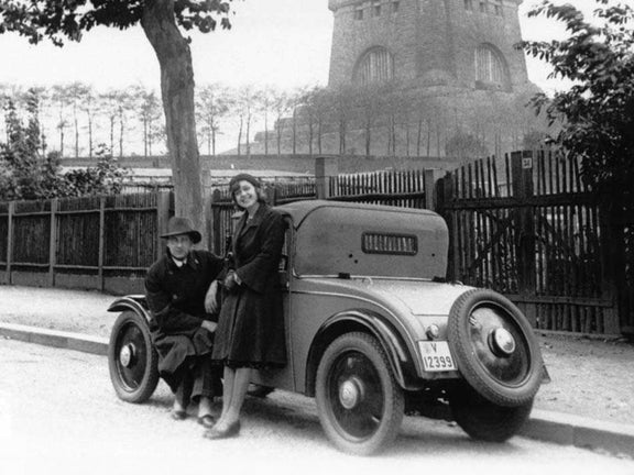 Black and white photo of two people leaning against a DKW Front F 1