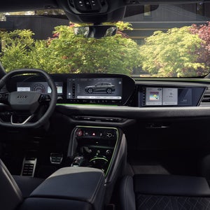 Vue depuis la banquette arrière vers le poste de conduite de l’Audi Q5 SUV. L’accent est mis sur l’écran panoramique avec l’Audi virtual cockpit et l’écran MMI.