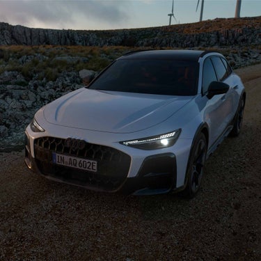 White A6 allroad e-hybrid driving through wind farm