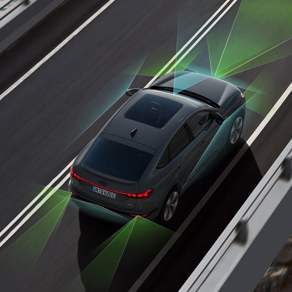 Der Q6 Sportback e-tron von schräg oben. Vom Heck und der Front aus unterteilen grüne und blaue Vektoren die Flächen hinter und vor dem Fahrzeug.