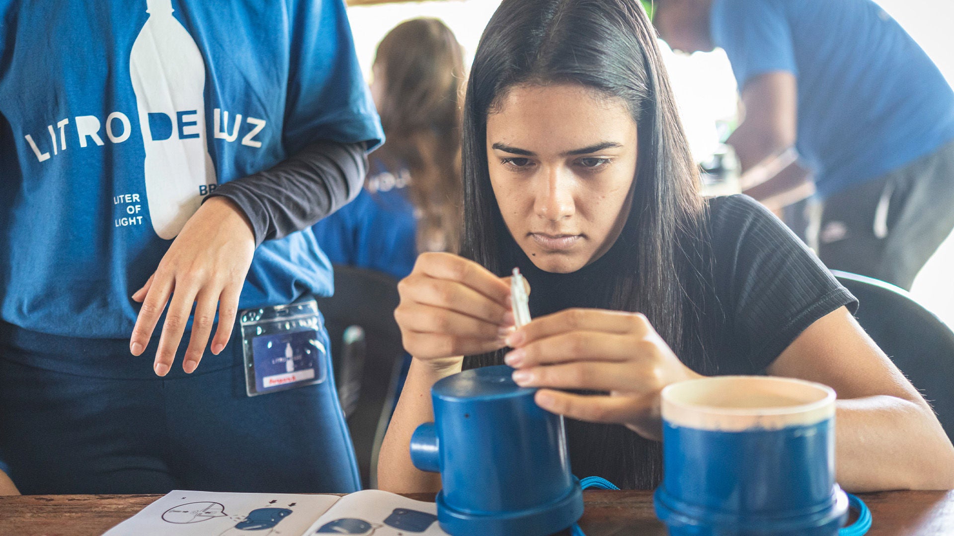 Eine junge Frau bastelt an einer Lichtquelle.