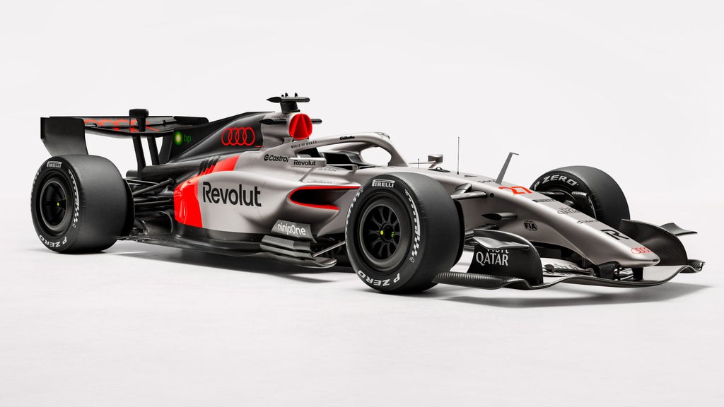 Der Audi Formel-1-Rennwagen R26 mit Rennlakierung in Schwarz, Grau und Rot steht in einem hellen Studio