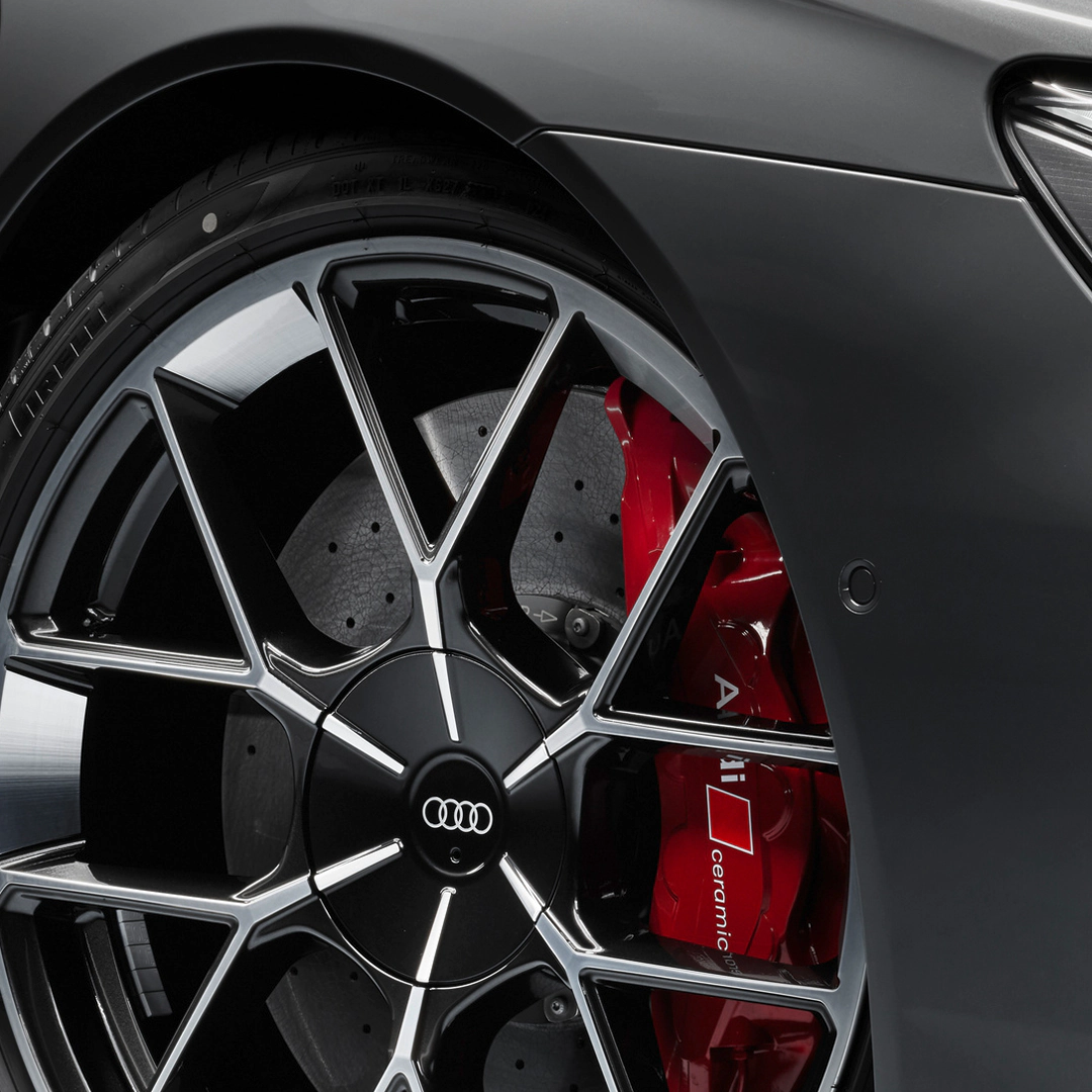Close-up of an Audi wheel with red brake caliper and ceramic brakes.