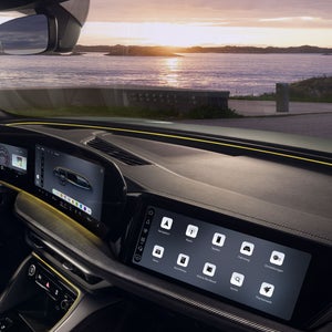 Blick durch das Beifahrerfenster in das Cockpit des SQ5 Sportback. Im Fokus das gelbe Interaktionslicht am unteren Rand der Windschutzscheibe.