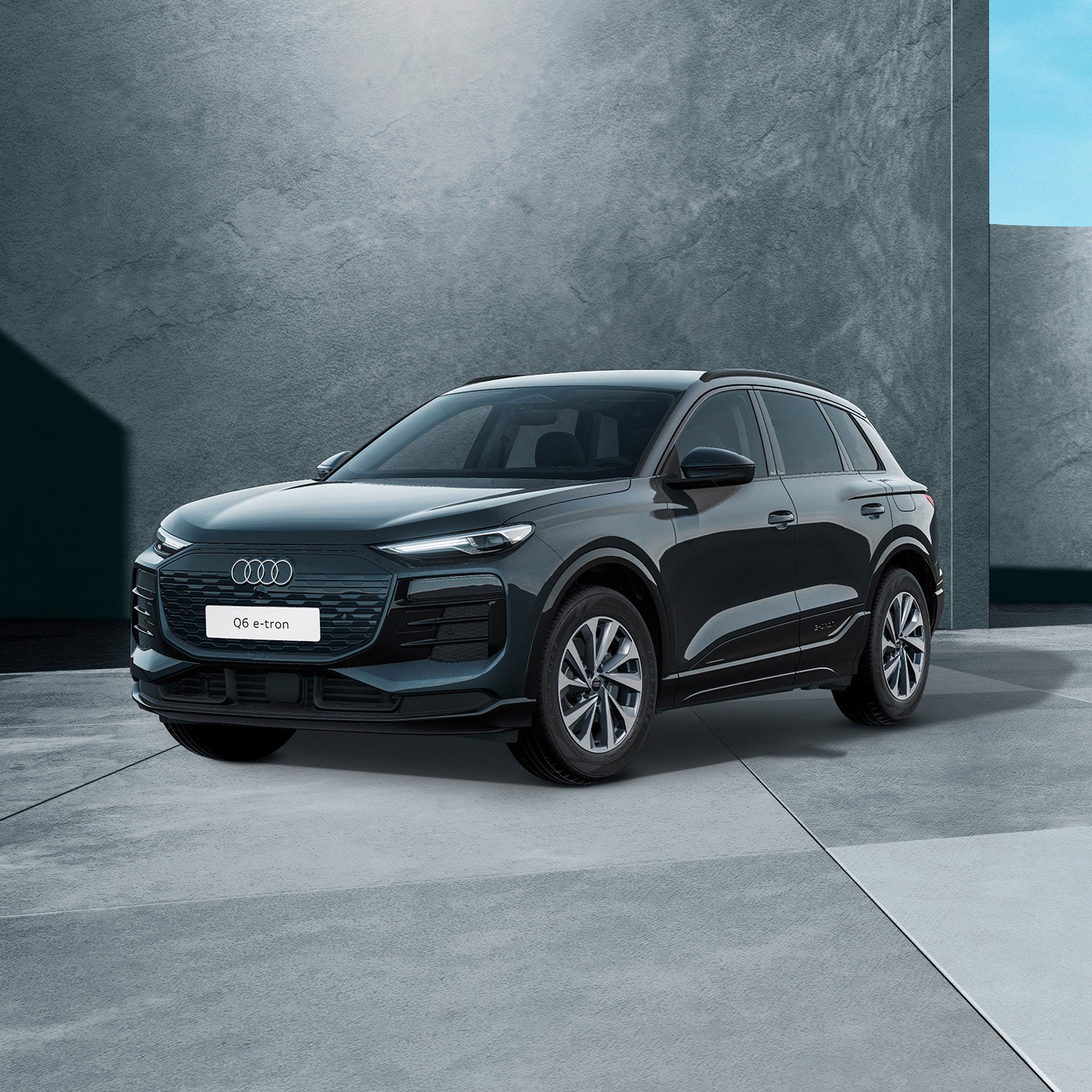 Ein schwarzer Audi Q6 e-tron SUV quattro von schräg vorne fotografiert vor einer modernen Kulisse.
