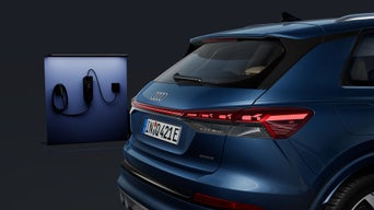 Fokus auf das Heck des Q4 SUV e-tron von der Seite, im Hintergrund eine moderne Ladesäule.