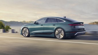 Seitenprofil des S6 Sportback e-tron, welcher auf einer Straße entlang des Meeres fährt. Im Hintergrund sind Berge zu sehen.