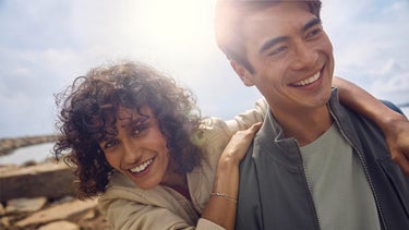 Frau lehnt sich lachend an einen Mann