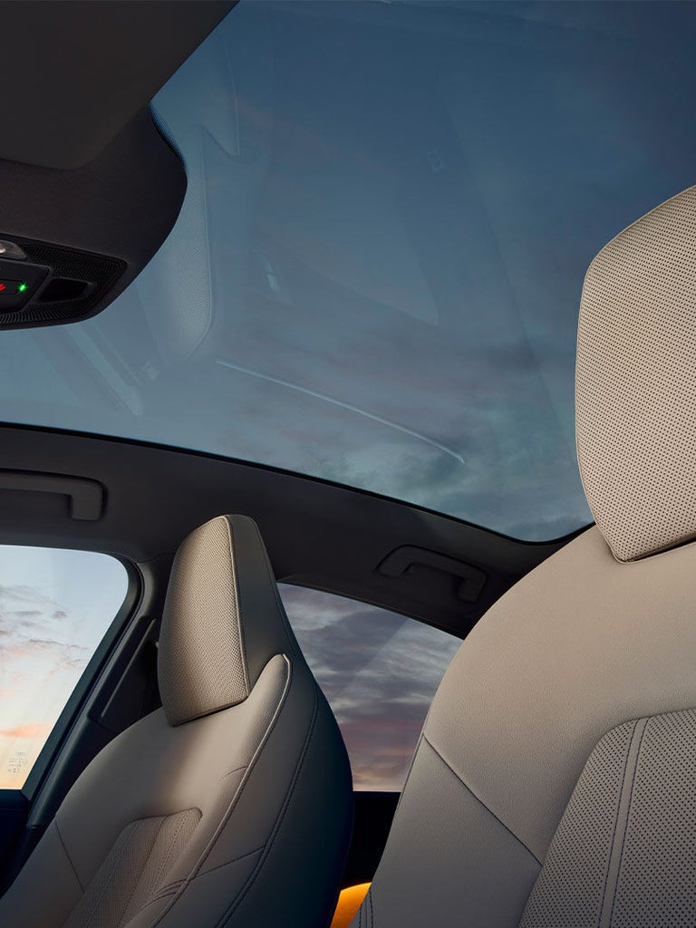 Blick von innen durch das Panorama-Glasdach der Audi A5 Limousine mit sichtbarem Dachhimmel und Vordersitz.