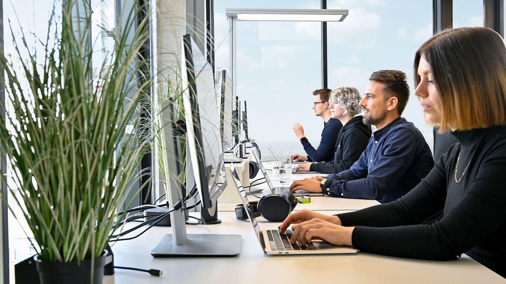 Employees of the Audi Software Development Center are at work and have laptops in front of them