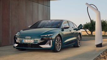 Der S6 Sportback e-tron im schrägen Frontprofil, während er an eine Ladestation angeschlossen ist.
