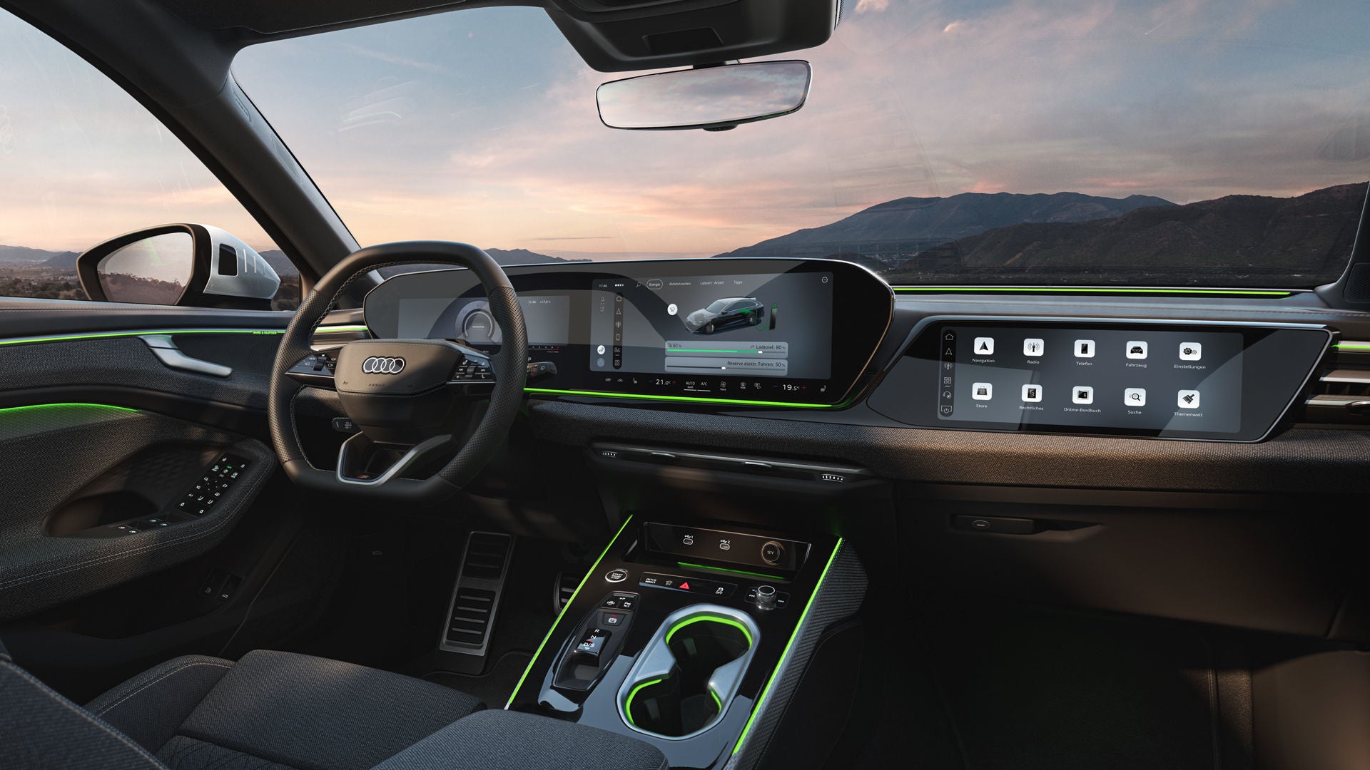 Blick auf die Displays und das Lenkrad im Cockpit des A6 Avant e-hybrid. Durch die Windschutzscheibe sind Berge zu sehen.