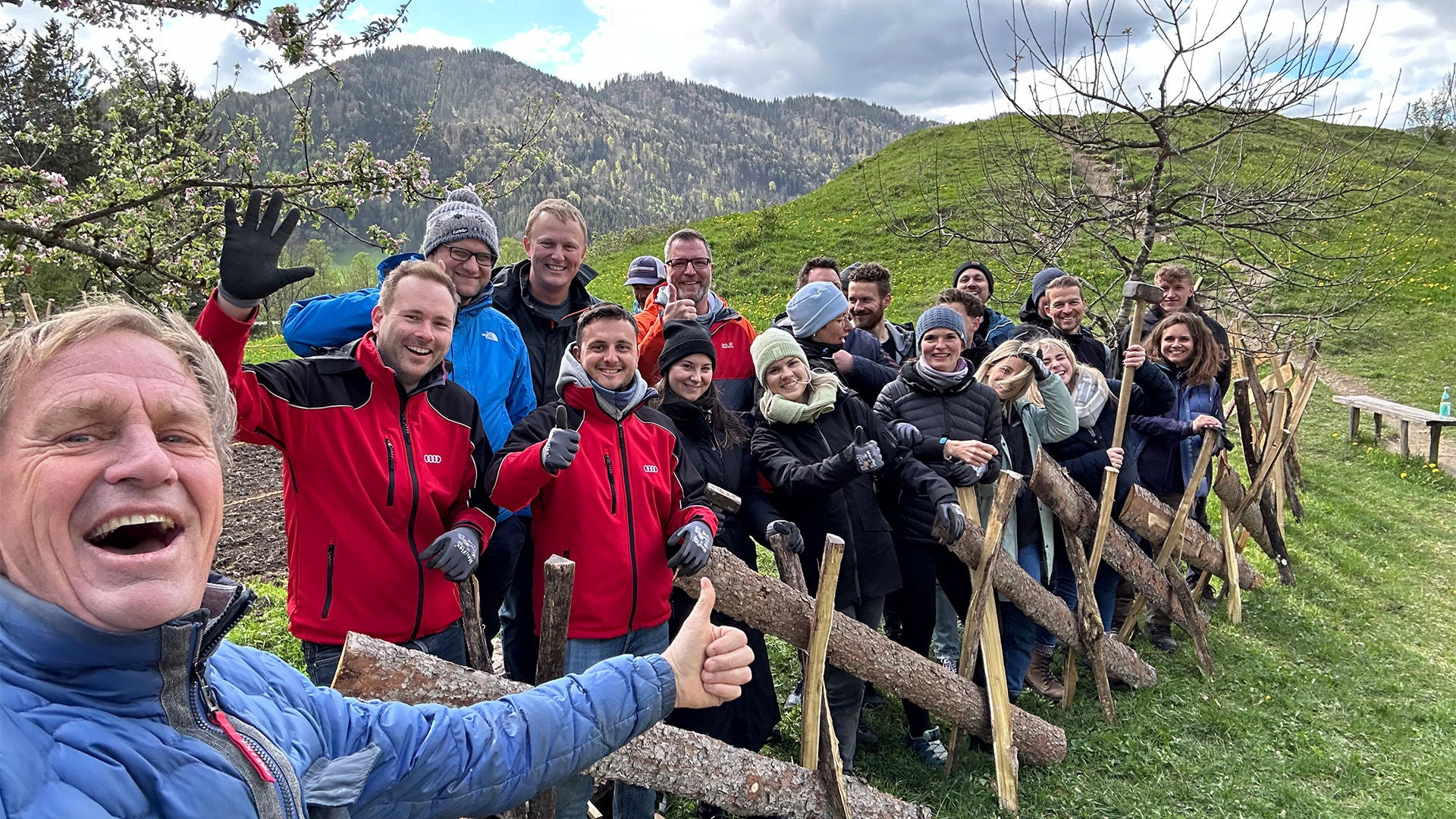 Group of helpers pose for a group photo in front of a self-built fence