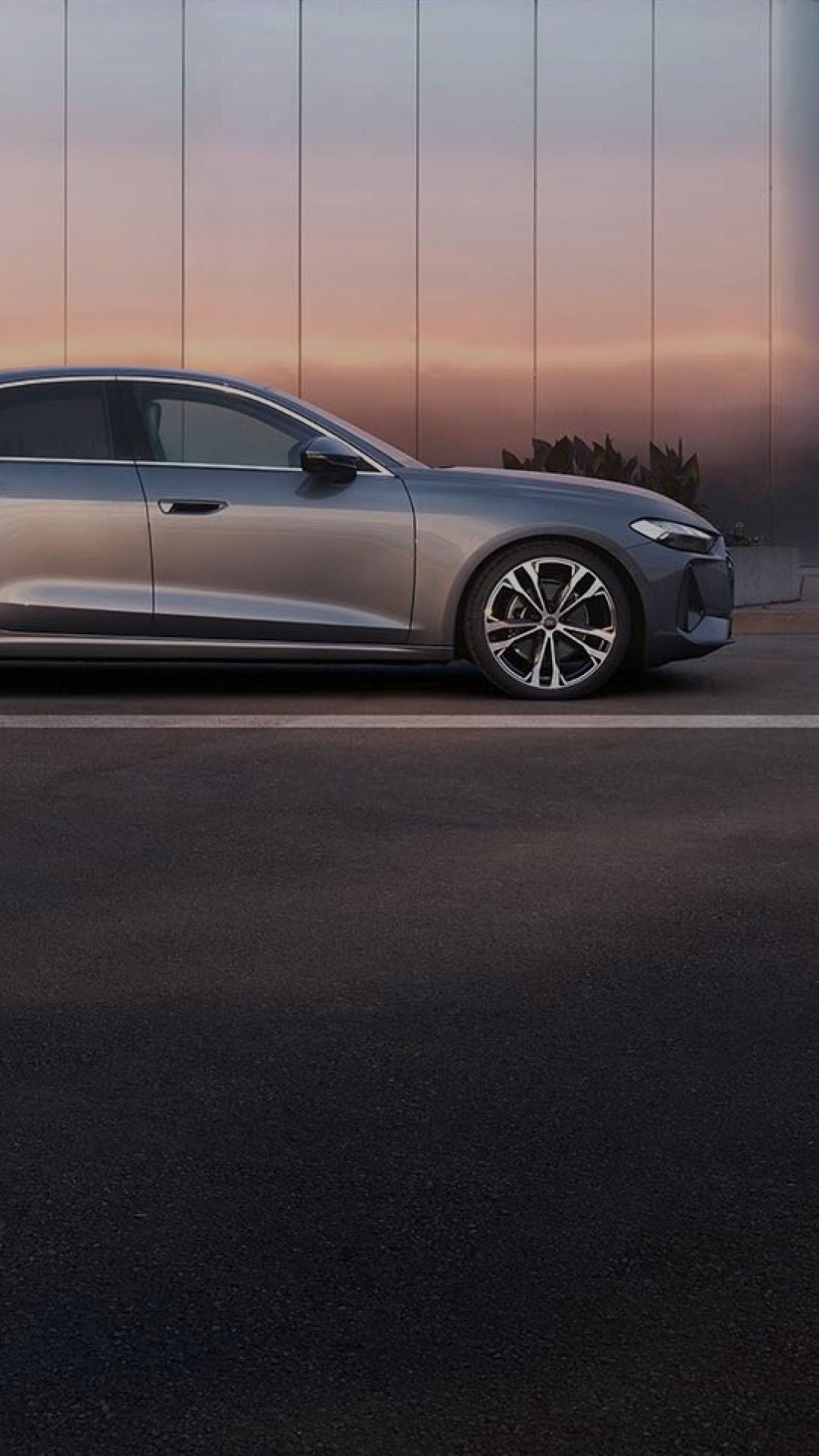 Chrome Audi in front of modern office building with a gradient sunset reflection