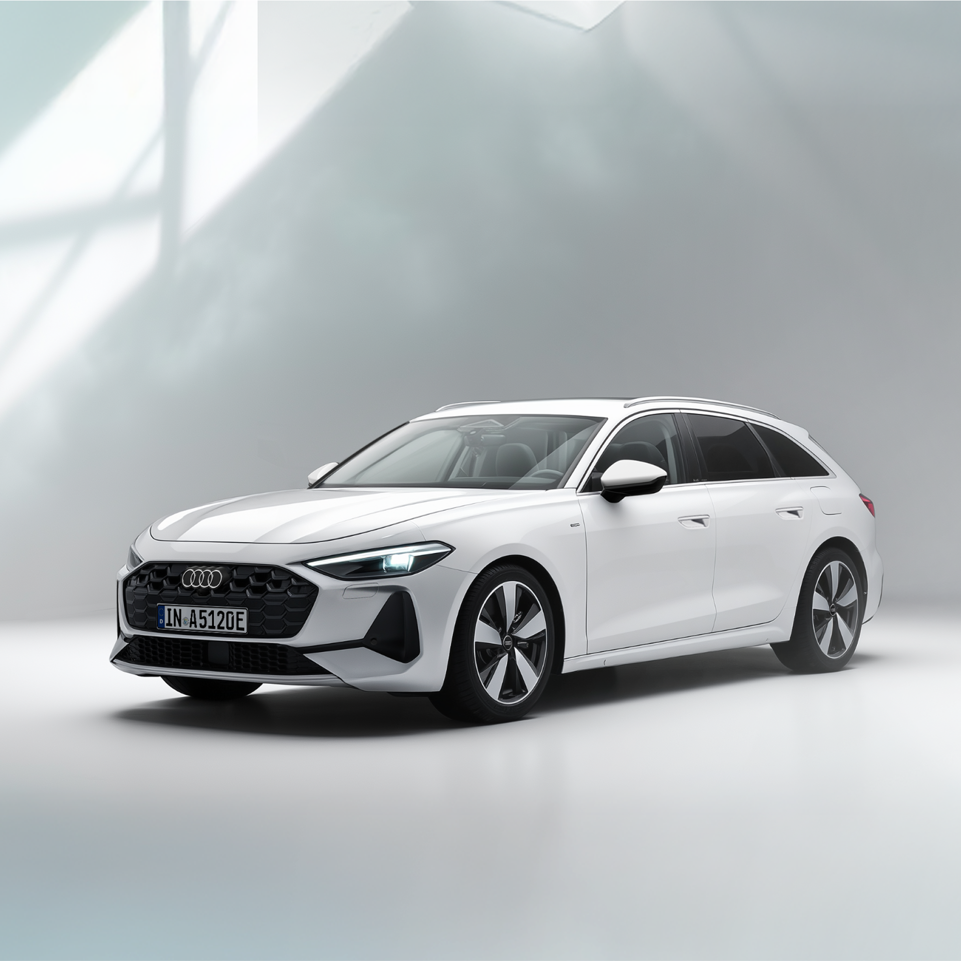 Ein weißer A5 Avant 220 kw e-hybrid steht seitlich vor einem beigen Gebäude