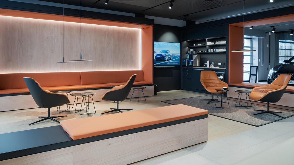 Eine Lounge mit LED-Beleuchtung und hellbraunen Ledersesseln