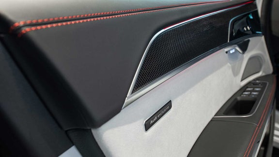 Door panel with red stitching and Audi exclusive badge.
