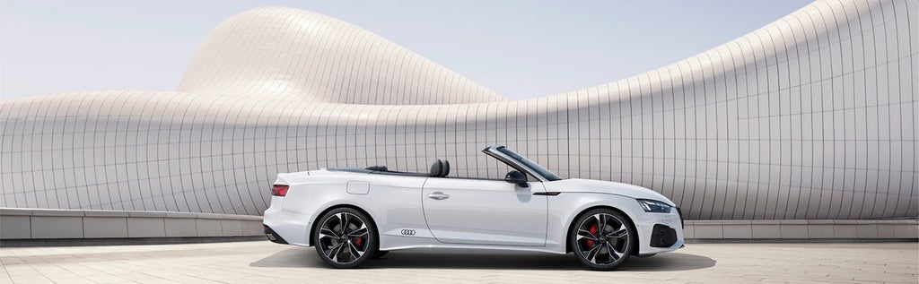  A white Audi vehicle parked in an urban setting on a sunny day