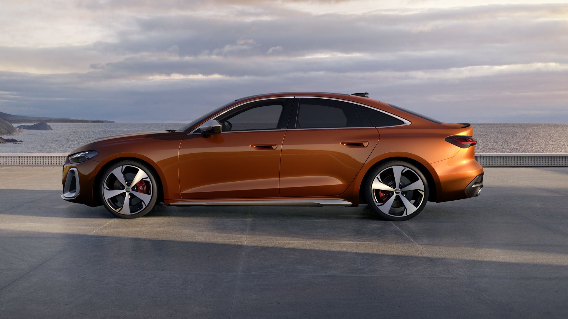 Die S5 Limousine steht im Seitenprofil auf einer Promenade an der Küste. Das Fahrzeug ist in Ipanemabraun Metallic lackiert.